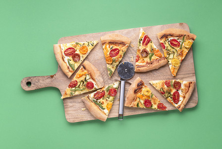 木制切板上的意大利比萨饼切片绿色背景旁观披萨的原始面条美味的春季食物传统的意大利餐图片