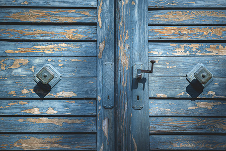 在门把手上贴精细的蓝色油漆古老的蓝色木门用油漆和门把手的旧木图片