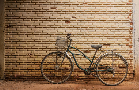 水泥墙附近的老旧自行车图片