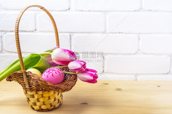与粉红手装饰鸡蛋和郁金香篮子中的图片