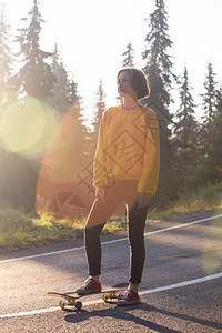 夏天的公路旅行美丽的风景和山路色女孩骑着滑板在横贯阿尔卑斯山罗马尼亚图片