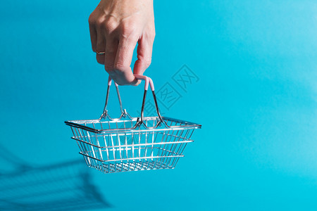 购买消费品篮子产价格蓝色背景的空篮子图片