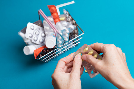 女用手药在背景消费品篮子产和药上使用丸图片