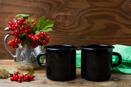 两辆黑火营罐头咖啡杯配有古董大壶和红莓树枝的空杯子用来促销设计图片