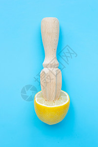 新鲜柠檬蓝色背景的木汁机图片