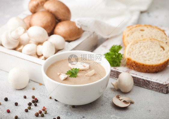 白碗盘奶油栗椰子香菇汤浅厨房背景和一盒生蘑菇新鲜面包图片