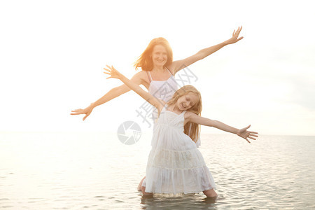 暑期家庭生活方式晚上海边带女儿的母亲图片