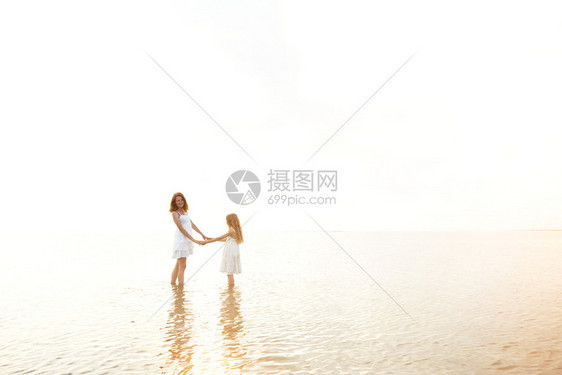 暑期家庭生活方式晚上海边带女儿的母亲图片