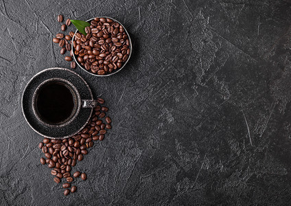 新鲜生有机咖啡豆和树叶黑底咖啡杯图片