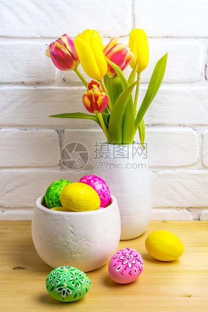 白色墙壁背景的郁金香和染色的鸡蛋图片