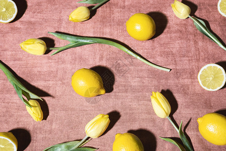 鲜柠檬和黄郁金香在阳光下的变装桌布上黄果和花样背景柑橘水果和郁金香的图象背景图片