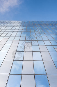 现代办公大楼的玻璃面罩和蓝色天空云的反射图片
