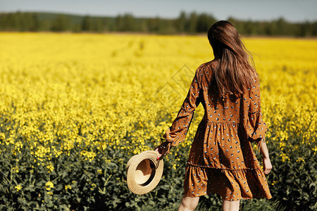 年轻女子身着黄色花裙在郊游图片