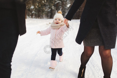 快乐的家庭在冬季城市公园散步可爱的小女儿肖像图片