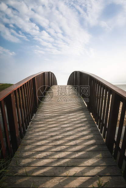 在北海沿岸阳光下锡尔特岛德国的木桥上在水和沙滩木桥通向天空的木桥上夏季漫游图片