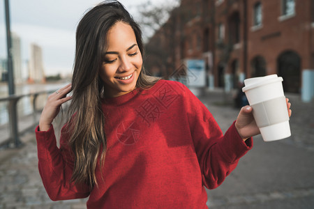 美丽的年轻女子在户外喝咖啡的肖像城市概念图片