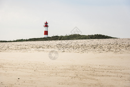 草丘和沙滩上的灯塔黄沙锡尔特岛北海德国阳光明媚的夏季海滩风景有灯塔和沙子图片