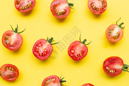 黄色背景上的切半番茄视图图片