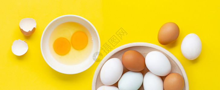 黄色背景上的新鸡蛋顶视图图片
