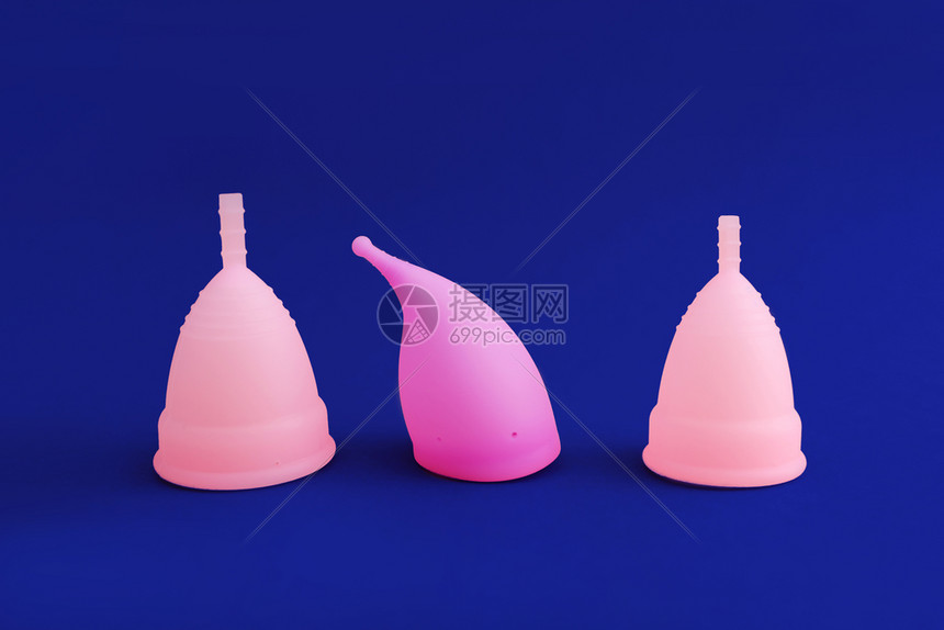 3个不同的粉红可重复使用的硅酮月经杯蓝底隔离女卫生妇科健康的概念图片