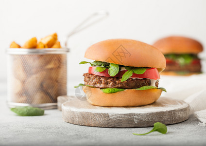健康素食肉免费汉堡在圆环切肉板上蔬菜在光背景土豆杂草图片