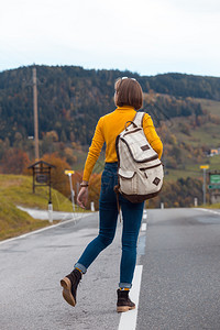 背包旅客沿着公路行走图片