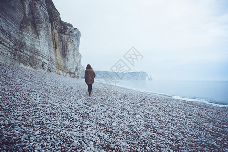 一个孤单的女孩在海洋中走古典图片