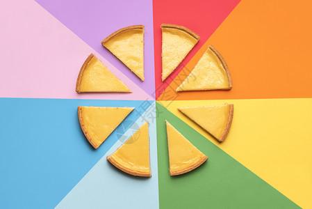 在彩虹背景上切成部分的自制芝士蛋糕彩虹背景上切成的芝士蛋糕8片饼著名的甜点图片