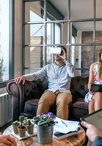 参加非正式工作会议的年轻人使用虚拟现实眼镜使用虚拟现实眼镜的人使用虚拟现实眼镜图片
