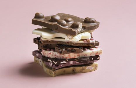 混合焦糖浆果巧克力白和黑放在堆叠中粉红色背景中紧贴巧克力图片