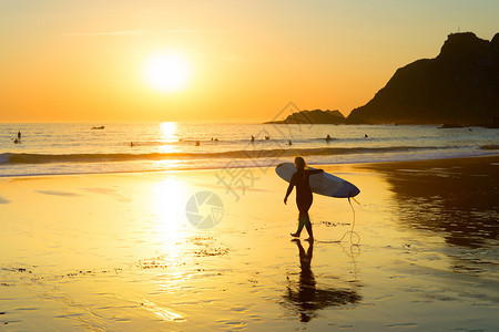 女冲浪者的剪影走到海边的沙滩萨格里斯阿尔加夫葡萄牙图片
