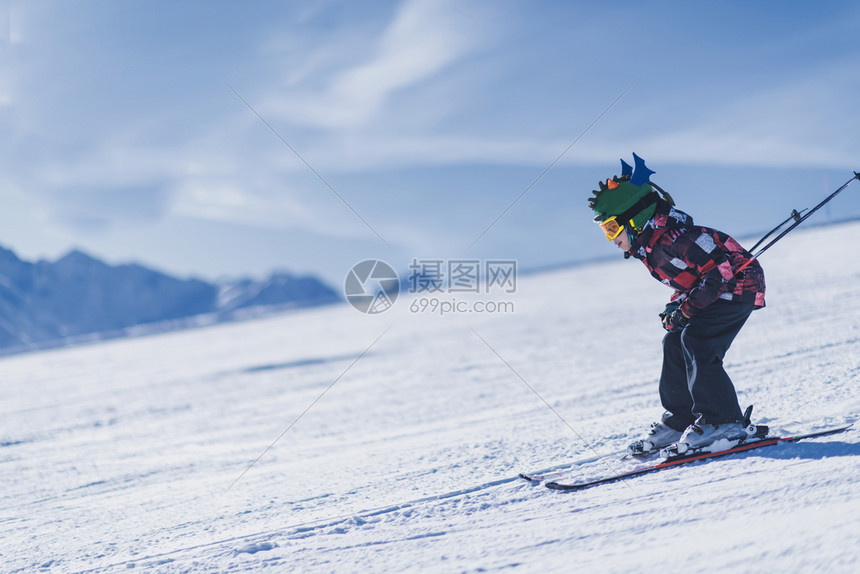 小孩带着头盔护目镜滑雪图片