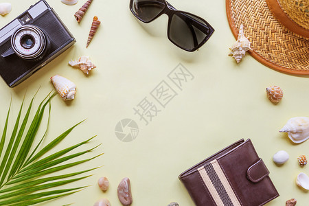男子和旅行者附件绿色热带棕榈叶照相机贝壳和太阳镜以黄色背景带有复制空间顶视旅行或度假概念平淡的暑假背景图片