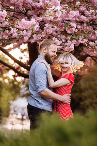 年轻夫妇拥抱在樱花树下图片