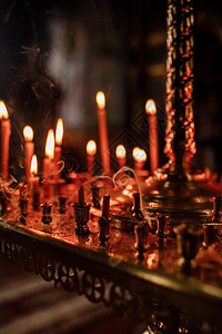 许多蜡烛晚上在教堂燃烧一群在黑暗中燃烧的蜡烛图片