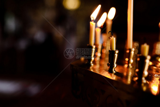 许多蜡烛晚上在教堂燃烧一群在黑暗中燃烧的蜡烛图片