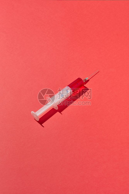 红血清或塑料注射针筒20毫升的疫苗用于在红色背景下注射静脉有硬影子复制空间一次红血注射器或有阴影的疫苗图片