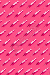 来自无菌塑料注射器的垂直保健模式注射药物或针头的疫苗以粉红色炎热柔软的阴影为背景高视线配有注射液的一次器健康模式图片