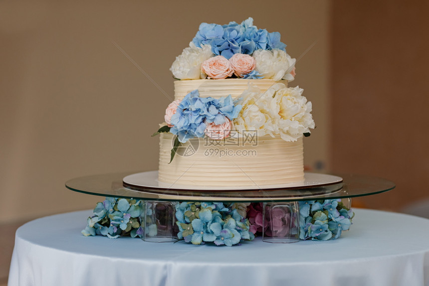 白结婚蛋糕有蓝花兰和粉红玫瑰在桌子上时尚的鲜花结婚日白蛋糕蓝花兰和粉红玫瑰在桌子上时尚的鲜花婚礼日图片