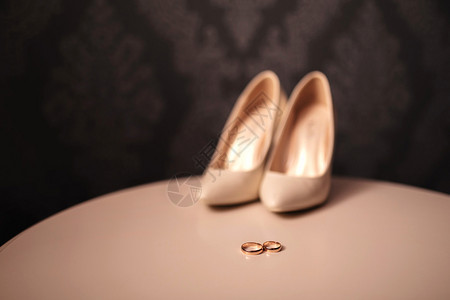 婚礼装饰品详细说明了白桌上的新娘和郎物品婚礼装饰详细说明了新娘和郎在白桌上的物品新娘和郎在早上两个婚礼金戒指和新娘郎在的鞋子订婚图片
