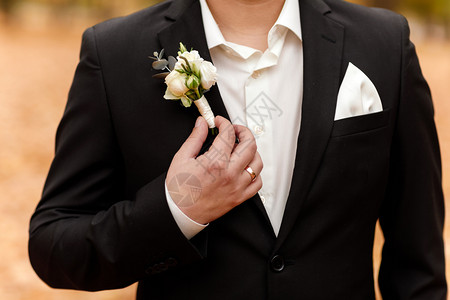 新郎穿着深色西装和白衬衫婚礼仪优雅西装日白玫瑰花黑西装和白衬衫婚礼服图片