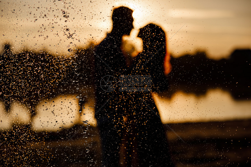 情侣在日落的湖边拥抱接吻图片