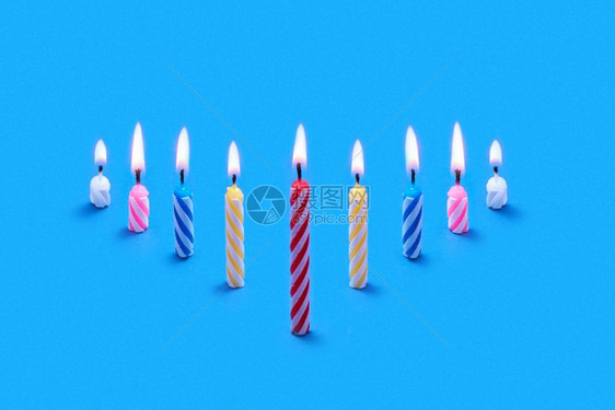 在蓝背景下烧蛋糕和甜点的节日蜡烛构成复制空间图片