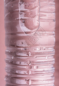 粉红色背景的塑料瓶中冷水瓶宏观图像图片