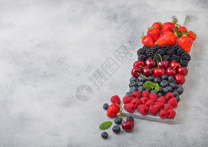 白大理石板上的新鲜有机夏季果酱轻厨房桌底背景草莓蓝黑和樱桃图片