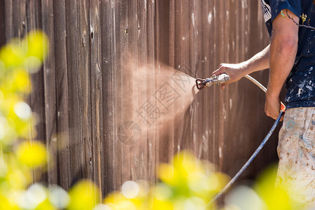 专业画家喷洒有木污的院子围栏图片