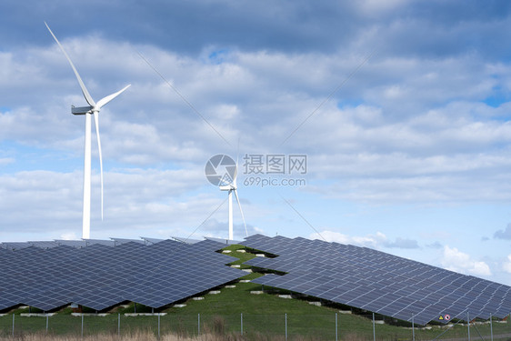 风涡轮机和太阳能电池板形成在蓝色天空下有云层的内河地带替代诱导植物图片