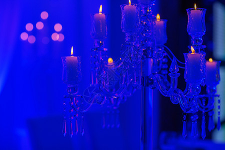 餐桌上的烛台是用白蜡制成的晶体做烛台为节日装饰或以蓝光庆祝有选择的焦点婚礼日餐桌上的烛台是用白蜡制成的晶体做烛台有选择焦点婚礼日图片