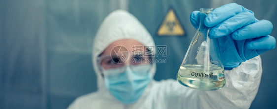 实验室内有细菌保护西装防服的女科学家有选择地关注表的试验管图片