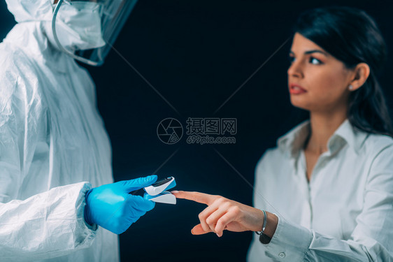 检查血氧水平和的医务人员身戴保护外科手术面罩的病人图片